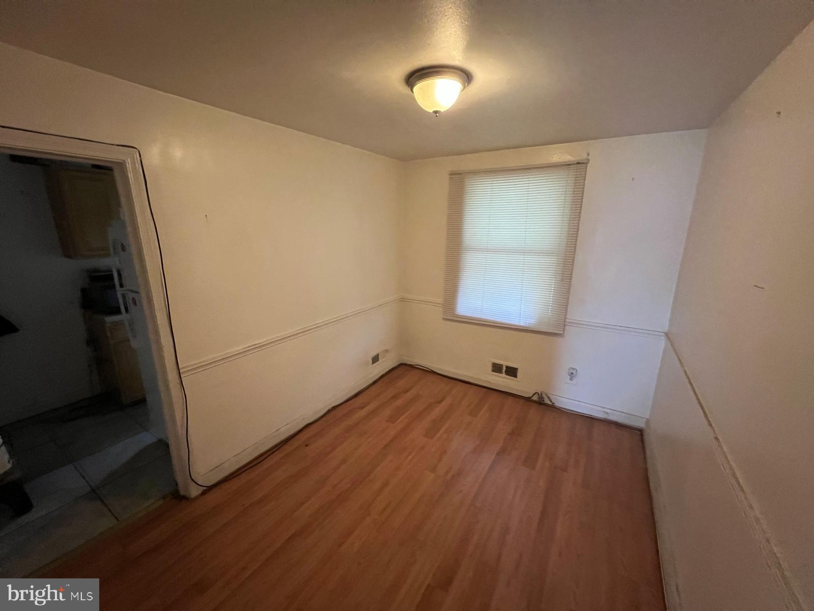 3917 Dudley Avenue Baltimore, MD 21213 - Photo 24 of 65 a view of an empty room with wooden floor and a window