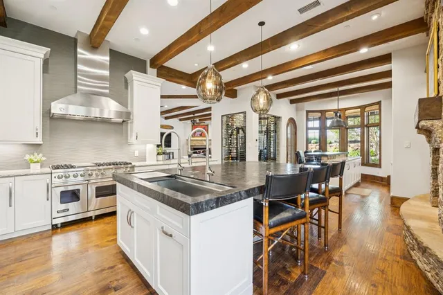 a kitchen with stainless steel appliances granite countertop a stove and a wooden floors