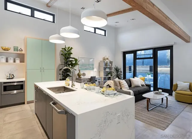 a kitchen with a stove a sink dishwasher and a dining table with garden view