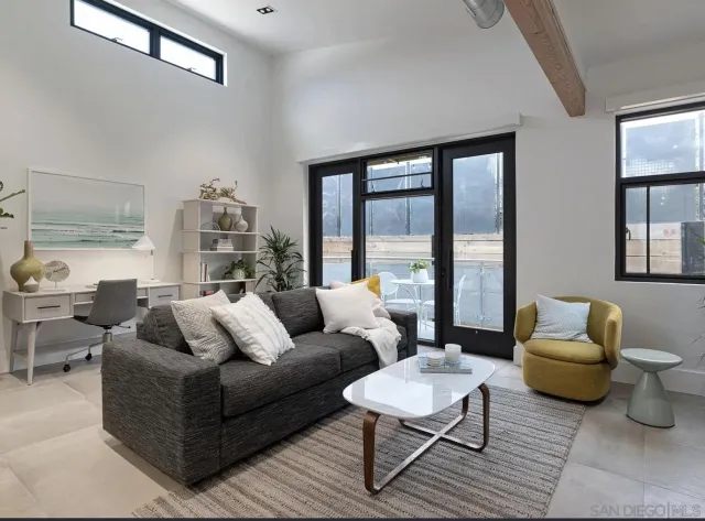 a living room with furniture and a potted plant on a dresser