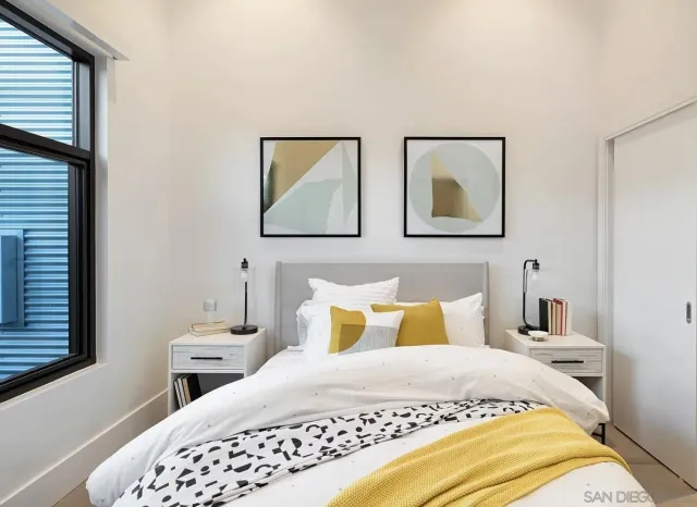 a bedroom with a bed and a painting on the wall