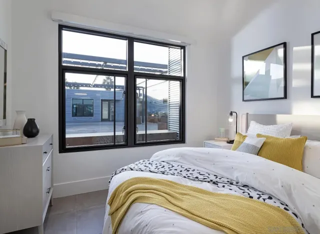 a bedroom with a bed and a large window with outer view