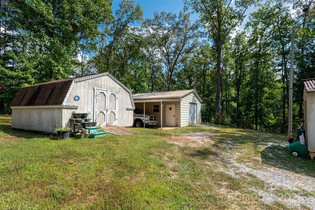 a front view of a house with a garden and trees