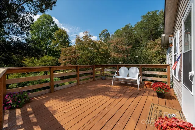a roof deck with table and chairs a barbeque with wooden floor and fence