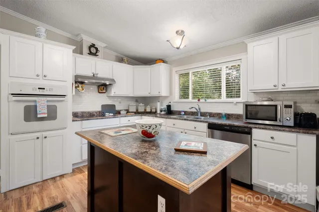 a kitchen with stainless steel appliances granite countertop a sink stove and cabinets