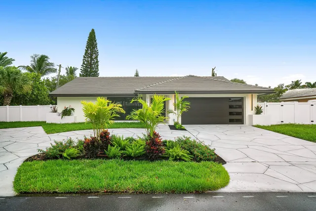 a front view of a house with a yard and a garage