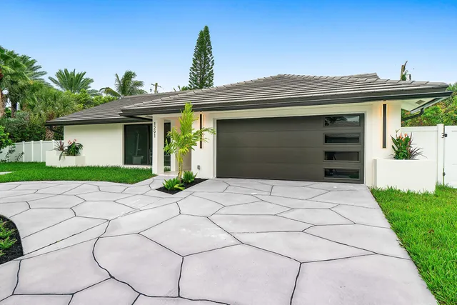 a front view of a house with a garden and yard