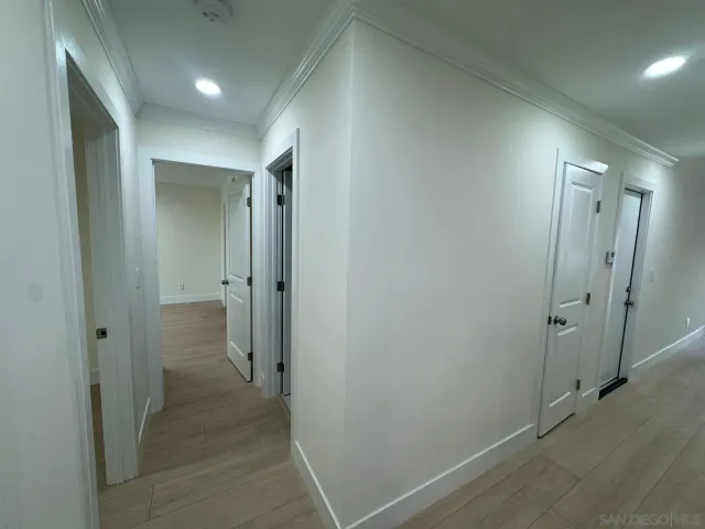 wooden view of a hallway with an empty room