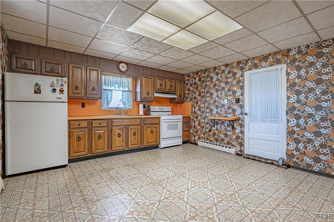 111 Maple Street Coplay, PA 18037 - Photo 9 of 38 a kitchen with stainless steel appliances a stove a sink and a refrigerator with cabinets