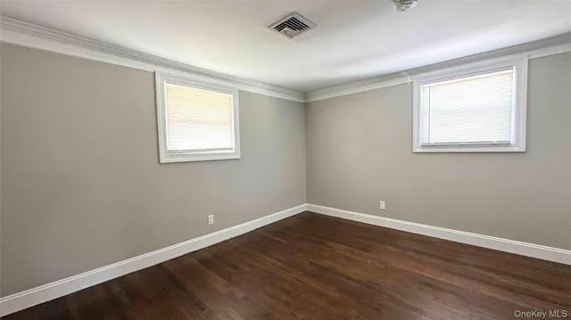 a view of a room with wooden floor and windows