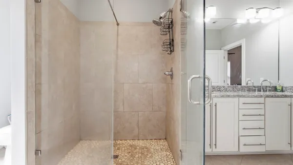a bathroom with a granite countertop sink a mirror and a shower