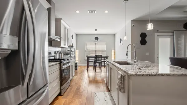 a kitchen with stainless steel appliances granite countertop a refrigerator and a sink