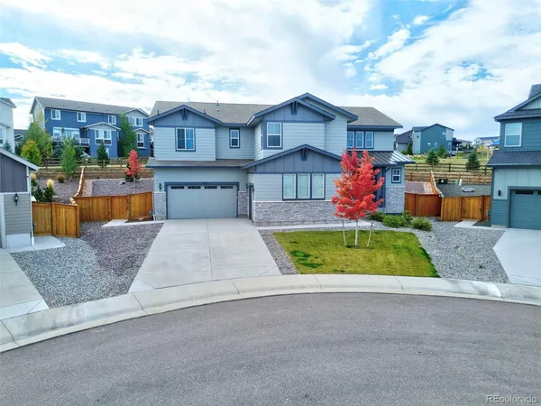 a front view of a house with a yard and potted plants