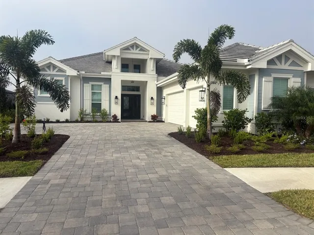 a front view of a house with a yard and potted plants