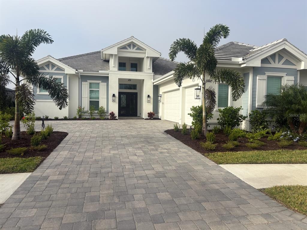 a front view of a house with a yard and potted plants