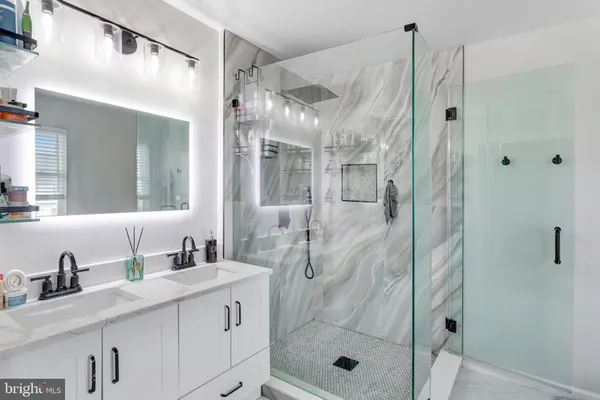 a bathroom with a shower sink and mirror