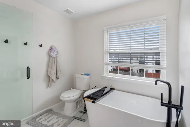 a bathroom with a sink a toilet and a window