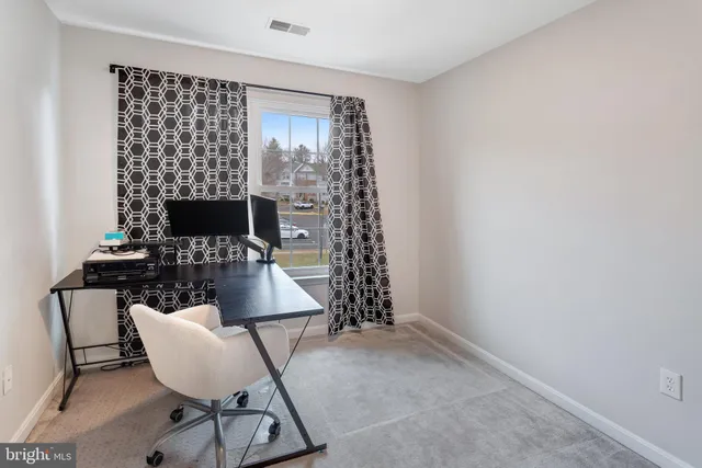 a view of a room with a chair and potted plant