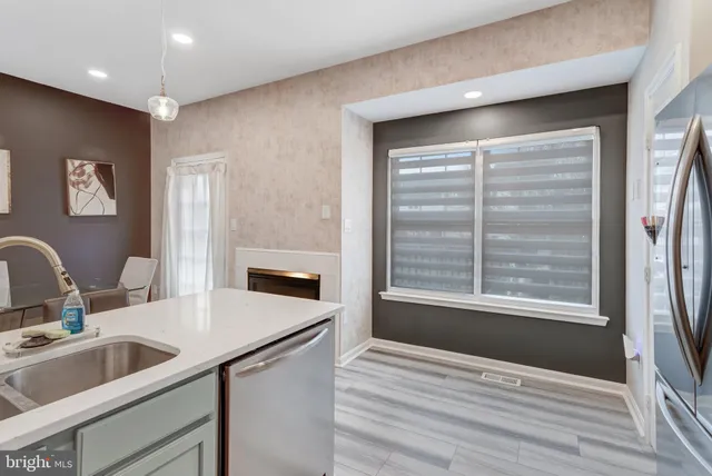 a kitchen with a sink cabinets and wooden floor