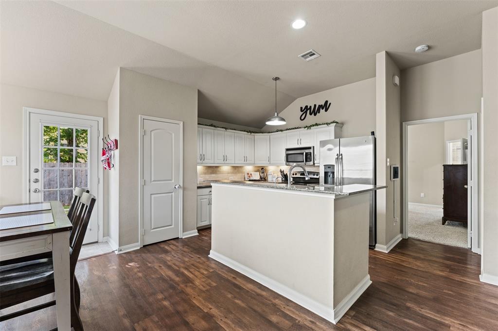 10313 Condor Loop Waco, TX 76708 - Photo 15 of 33 Kitchen featuring white cabinetry, stainless steel appliances, a kitchen island with a stone-finish countertop, wood-finish flooring, and recessed lighting