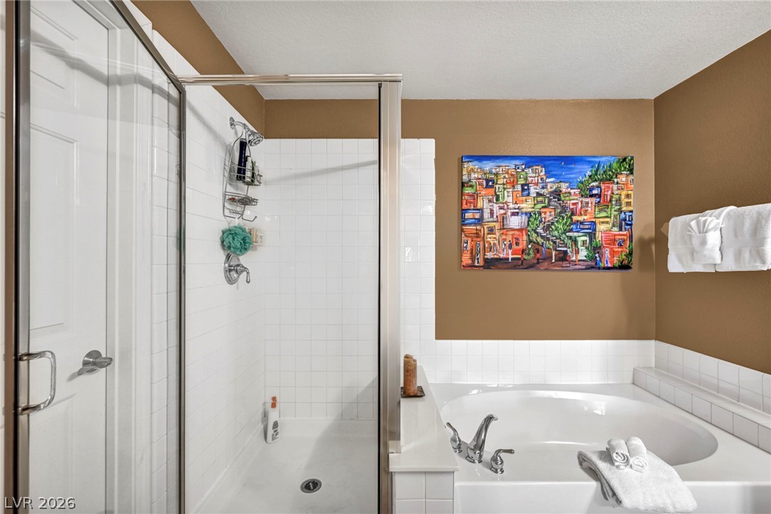 10730 Amber Ridge Drive, Unit 101 Las Vegas, NV 89144 - Photo 24 of 32 Relax and refresh in this bathroom featuring a separate walk-in shower and soaking tub.