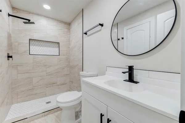 a bathroom with a sink a toilet and a mirror