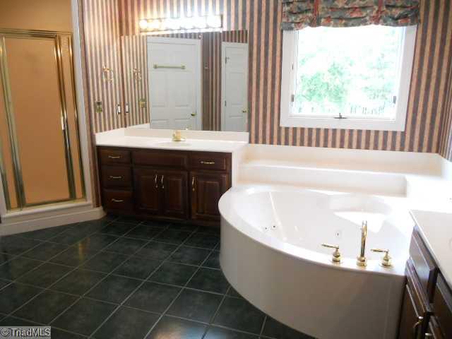 185 Williams Road Madison, NC 27025 - Photo 11 of 16 Master Bath/Spa. His & Her vanities, separate shower, jetted tub. Walk in closet off of bath.