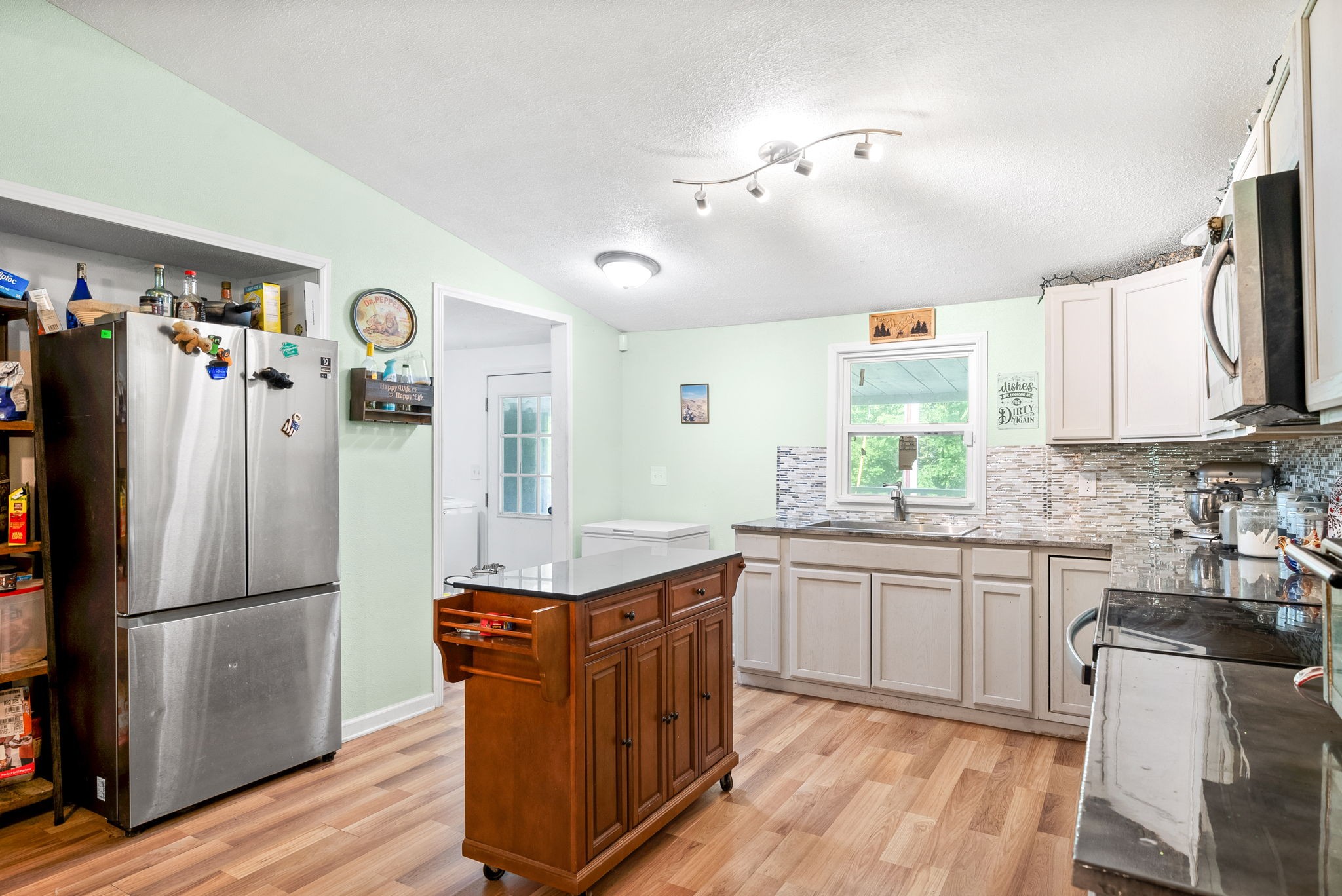 110 Little Fork Road Cumberland City, TN 37050 - Photo 11 of 32 a kitchen with stainless steel appliances granite countertop a refrigerator a sink dishwasher a stove and white countertops with wooden floor