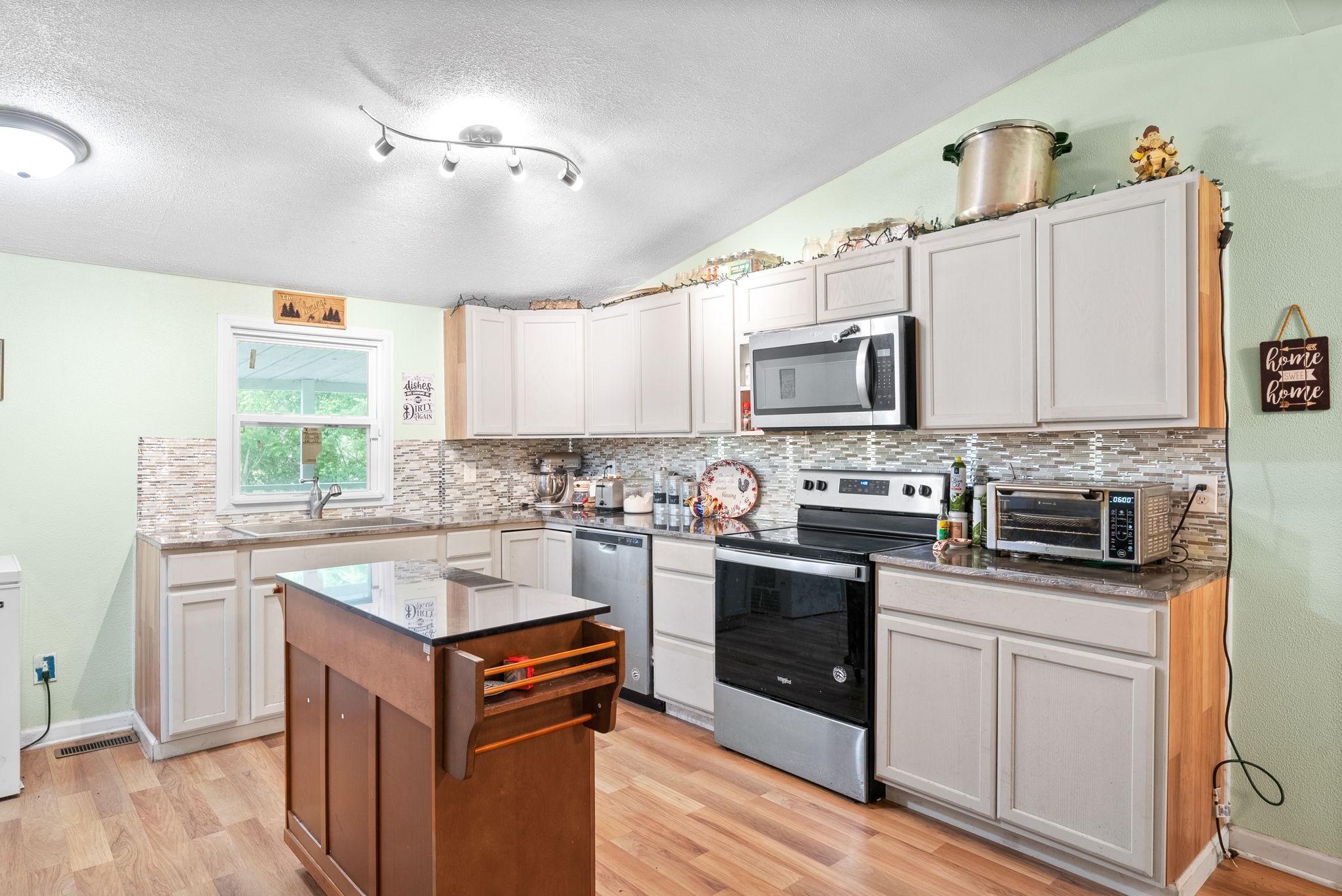 110 Little Fork Road Cumberland City, TN 37050 - Photo 10 of 32 a kitchen with stainless steel appliances granite countertop a stove top oven a sink dishwasher and a microwave oven with cabinets