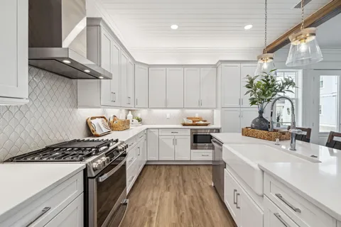 a kitchen with granite countertop a sink stove and cabinets