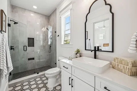 a bathroom with a double vanity sink toilet and shower