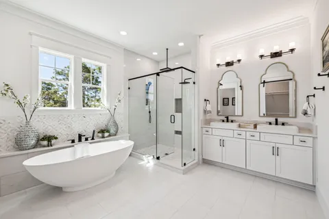 a spacious bathroom with double vanity a mirror a bathtub and a shower