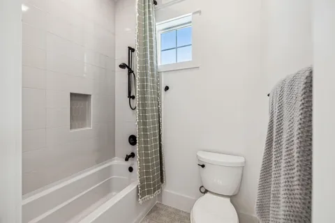 a bathroom with a toilet and a shower