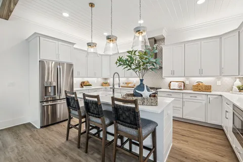 a kitchen with granite countertop a table chairs stove and refrigerator