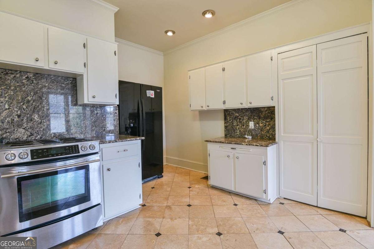 120 Tusten Street Elberton, GA 30635 - Photo 15 of 49 a kitchen with granite countertop white cabinets and stainless steel appliances