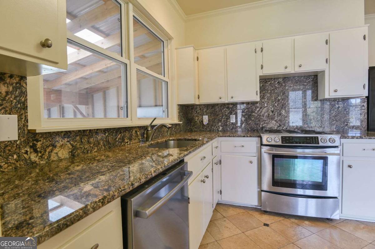 120 Tusten Street Elberton, GA 30635 - Photo 16 of 49 a kitchen with granite countertop a sink stainless steel appliances and cabinets