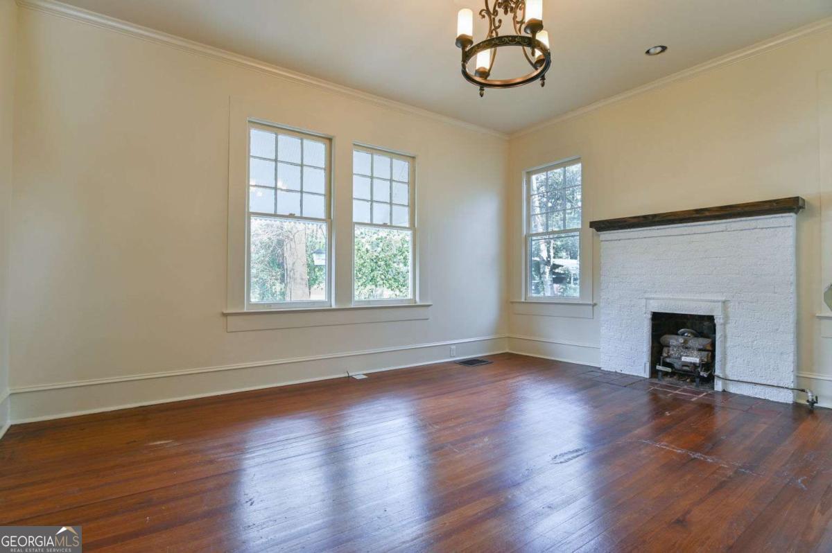 120 Tusten Street Elberton, GA 30635 - Photo 23 of 49 an empty room with wooden floor fireplace and windows