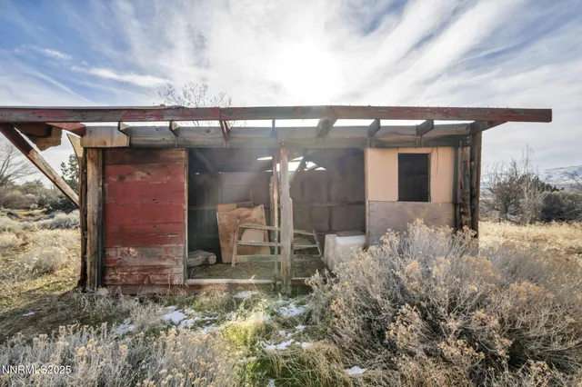 a view of a dry yard with wooden fence