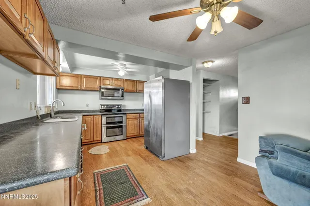 a kitchen with granite countertop stainless steel appliances white cabinets and a sink