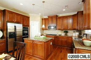 79240 Ridgehaven Road, Unit 141 Lancaster, SC 29720 - Photo 3 of 6 a kitchen with stainless steel appliances granite countertop a refrigerator a sink dishwasher a stove with wooden cabinets and floor