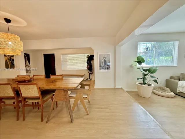 a view of a dining room with furniture and a potted plant