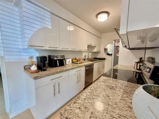 a kitchen with stainless steel appliances granite countertop a sink stove and cabinets