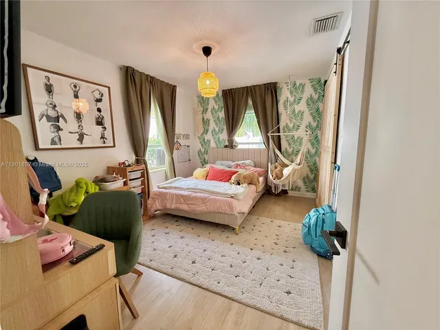 a bedroom with furniture and a large window