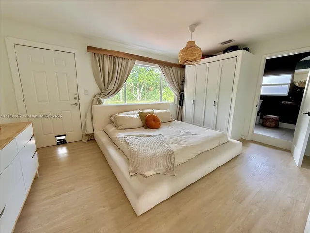 a bedroom with a bed and a large window
