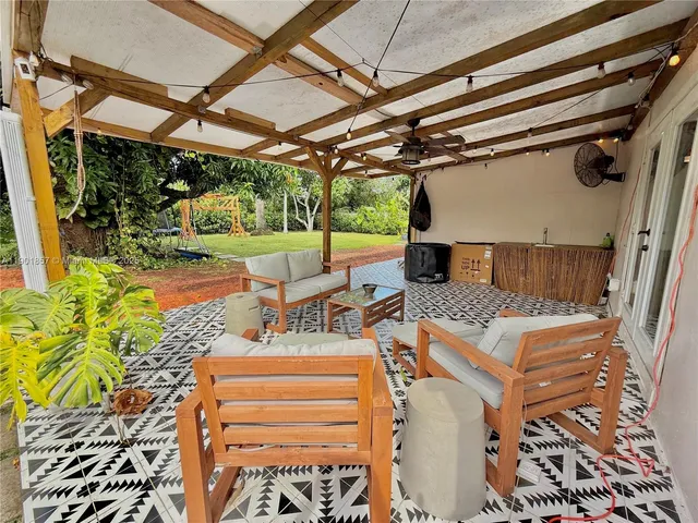 a view of a patio with table and chairs with wooden floor and fence