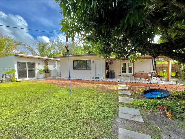 a view of a house with backyard and sitting area