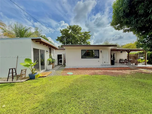 a view of a house with pool and a yard