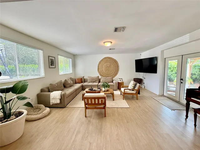 a living room with furniture flat screen tv and a large window