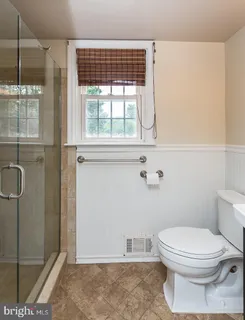 a bathroom with a toilet and a shower