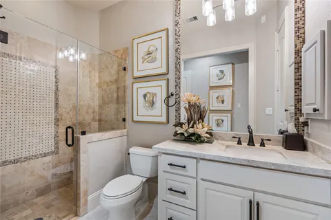 a bathroom with a double vanity sink toilet and shower